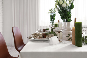 Beautiful table setting with eustoma flowers and eucalyptus for wedding celebration in room