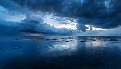 Obraz premium dramatic stormy seascape with dark blue clouds and reflections on calm water creating a moody atmosphere captured during twilight hours