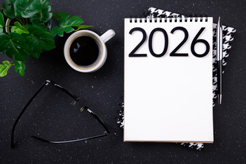 New year resolutions 2026 on desk. 2026 goals list with notebook, coffee cup, plant on black table. Resolutions, plan, goals, action, checklist, idea concept. New Year 2026 resolutions, copy space