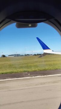 Window passenger point of view medium shot vertical video of plane landing to carrasco airport, canelones, uruguay