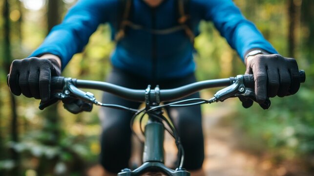 Close-up of male cyclist riding through forest trail in blue jacket