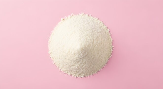 Conical pile of fine dry white powder presented from a top-down perspective on a smooth, solid light pink background.