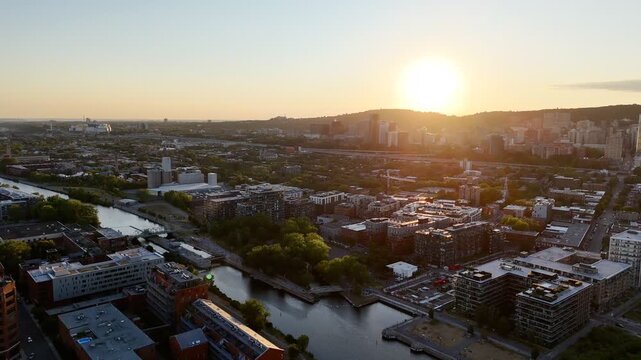 Aerial view of modern waterfront district with high-rise buildings and riverside paths, Montreal twilight skyline. g.