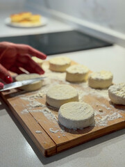Cutting and preparing fresh cheese cakes on a wooden board
