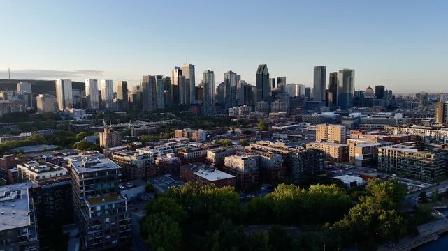 Aerial view of modern waterfront district with high-rise buildings and riverside paths, Montreal twilight skyline. g.