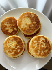 Golden cottage cheese pancakes syrniki on a white plate