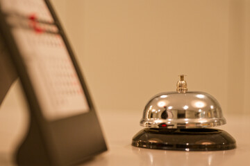 Service bell on counter with small desktop calendar beside