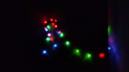Blurred bokeh of red and green decorative lights glowing in the dark, creating a festive and cozy atmosphere. Perfect for use in holiday themes, party backgrounds, or creative digital designs. This ph