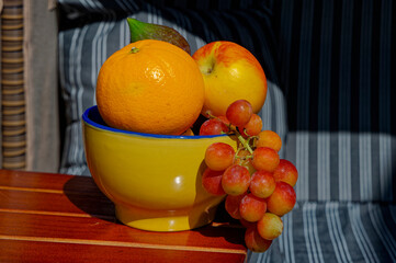 Bowl with various fruits on the table of a beach chair.