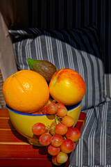 Bowl with various fruits on the table of a beach chair.