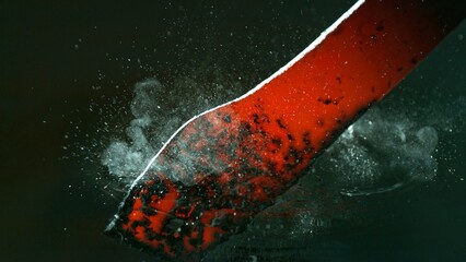 Close-up of glowing hot iron being quenched in cold water. Concept of metal forging and cooling.