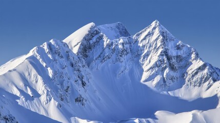 Naklejka premium Snow-Capped Mountain Peaks Against Clear Blue Sky in Winter Scene