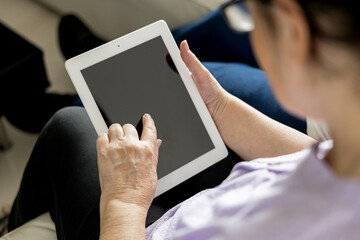 Senior woman using digital tablet with blank screen