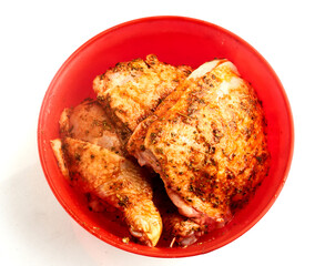 Marinated chicken pieces in a mixing bowl  isolated on white background

