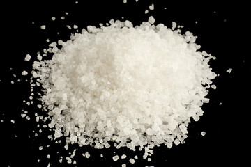 Coarse salt crystals in a close view isolated on black background
