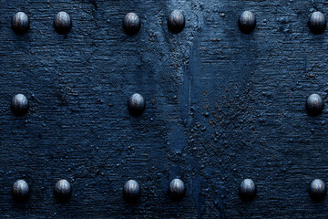 Dark blue textured metal surface with round metal studs