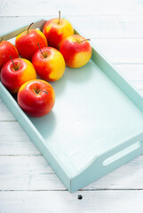 apples at blue tray, white wood table
