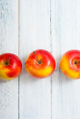 apple fruits in a row, white wooden table background