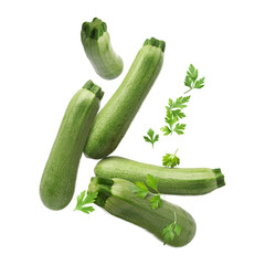 Fresh zucchinis and parsley falling on white background