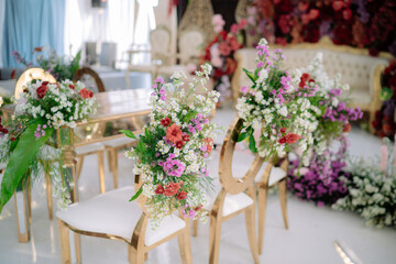 table, chairs and red, pink, orange, and white flowers in wedding decoration