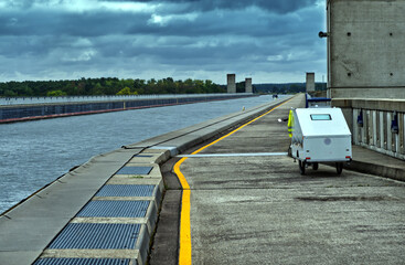 White camper trailer parked alongside magdeburg water bridge, navigable aqueduct crossing cloudy german landscape
