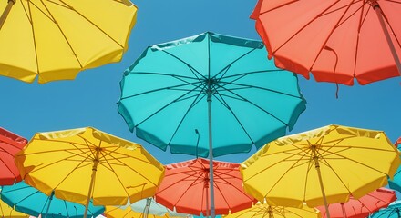 Colorful beach umbrellas form a vibrant canopy against a clear blue sky