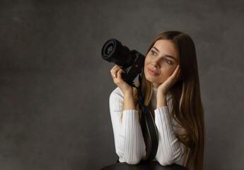 Obraz premium Portrait of female photographer with camera. Hobby, creativity, and professional equipment.