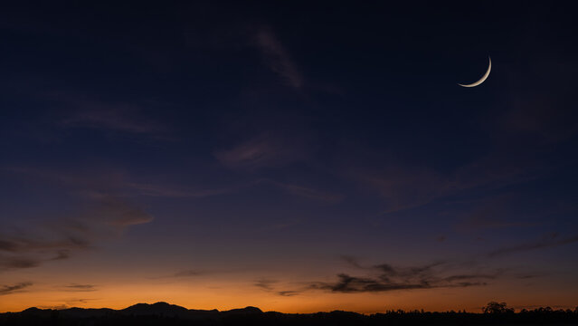 Crescent moon on dusk sky background, Twilight sky clouds over landscape mountain in summer evening, Religion of Islamic and free space text Ramadan Kareem, Eid Al Fitr, Eid Al Adha, Eid Mubarak