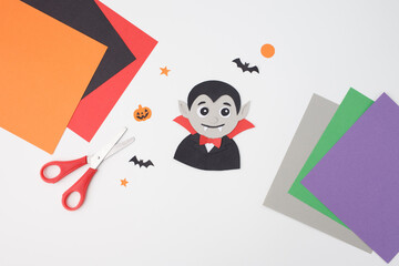 Handmade Halloween vampire paper art surrounded by craft tools, creative autumn classroom project for children, school education, art teacher resources, kids activity business,