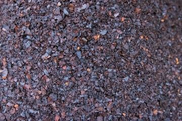 Pile of brown dirt with some black rocks in it