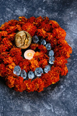 moon amulet and burning candle, quartz crystals, orange marigold flowers on abstract dark background close up. Wiccan altar for Mabon, samhain. witchcraft, esoteric spiritual ceremony, magic ritual