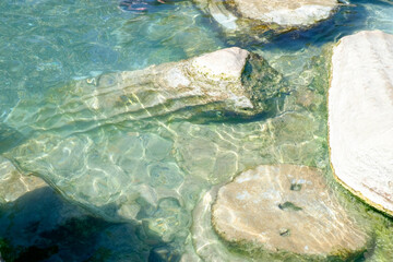 Rock is in the water and the water is clear