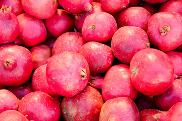 Pile of red fruit, including pomegranates