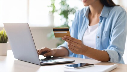 Young Woman Engaged in Online Shopping Using Credit Card While Sitting at Her Laptop in Cozy Room