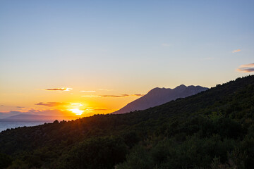 Sunset over the Adriatic Sea with a view of the mountain slope and the coast. Podaca village, Makarska Riviera, South Dalmatia, Croatia.