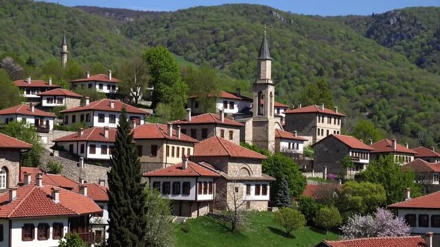picturesque May view of village with religious structures in mountainous region