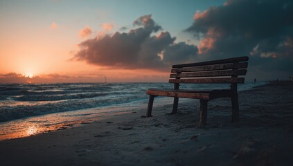 Empty wooden bench on a beach at sunset