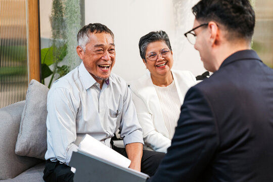 Cheerful senior couple meets financial advisor in modern office, discussing retirement planning, investment options, and insurance. Consultation helps clients manage finance with expert guidance.