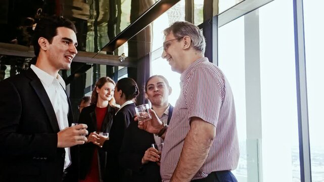Professionals network at corporate reception, smiling and chatting with drinks. Business event blends meeting, conference, seminar, workshop, teamwork, and collaboration in modern glass office. 4k