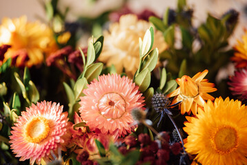 Autumn bouquet with vibrant strawflowers and mixed foliage in warm seasonal colors