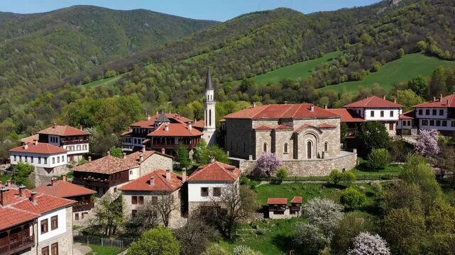 picturesque May view of village with religious structures in mountainous region