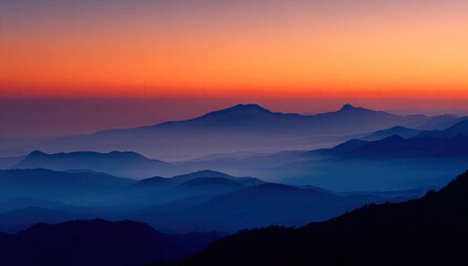 Obraz premium Sunset over hazy, layered mountains