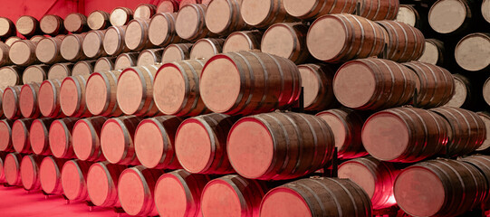 Numerous wooden barrels arranged in a striking, artistic manner with red light
