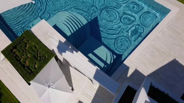 Aerial Top Down View of Outdoor Swimming Pool with Umbrella and Sun Lounger and Clear Water as Texture Background Concept