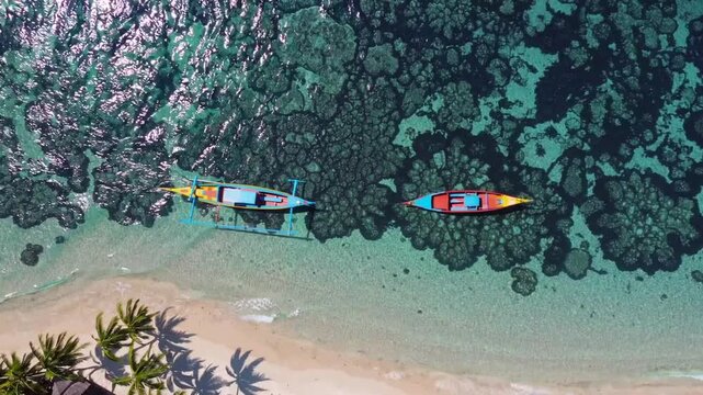 Top-Down Aerial Perspective of Traditional Boat Moored Near Tropical Lagoon and Coral Reef with Blue and Turquoise Ocean Waters