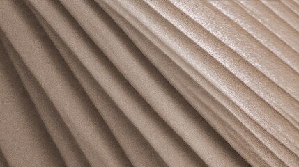Obraz premium Close-up texture of folded tan fabric with vertical pleats, smooth surface, subtle light reflections,
