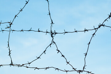 barbed wire against blue sky