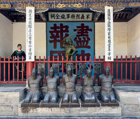 Kneeling statues of traitorous officials, their accomplices at Shi Quan Shrine with Shi Quan holding sward in historical Yue Fei Temple, Tangyin, Anyang, Henan, China. Heritage.