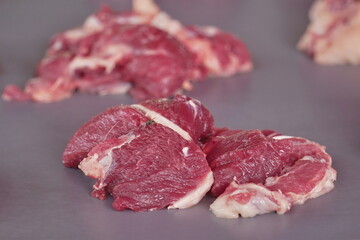 raw beef cut isolated on grey background.photographed at 45 degree angle closeup and detail