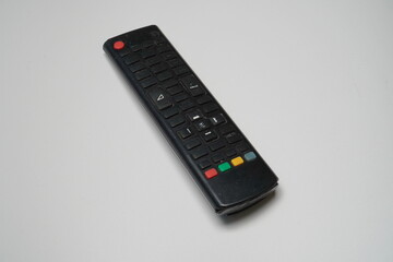black TV remote control diagonally isolated on a white background